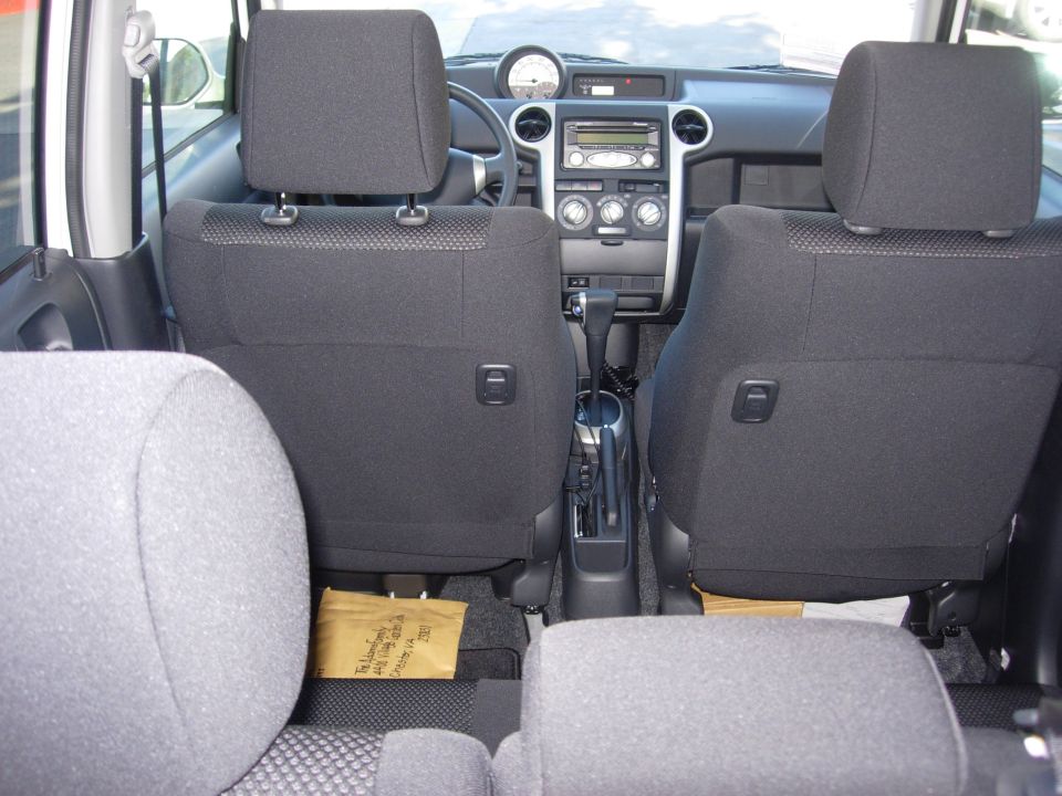 Black cloth car interior viewed from rear, showing dash, center gauge, radio and shifter.