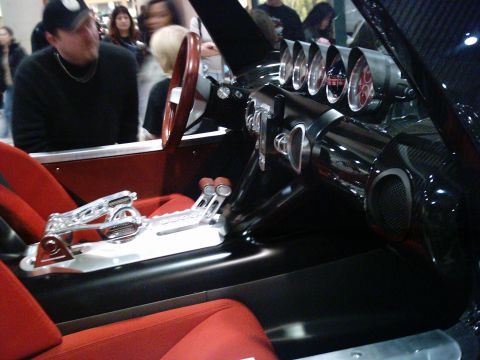 1986 Ford Bronco - Interior view of a custom vehicle red seats, a chrome shifter, and a dashboard with five prominent gauges.