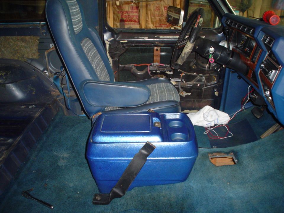 Interior of a 1984 Ford Bronco showing blue seats, dashboard, and center console