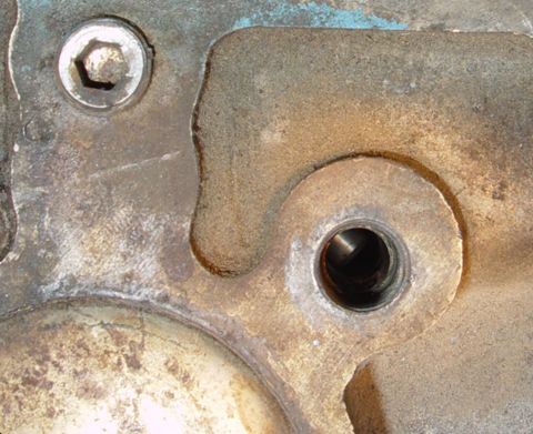 1969 Ford Fairlane - Detail of a weathered engine part, showing a bolt head and a central threaded opening.