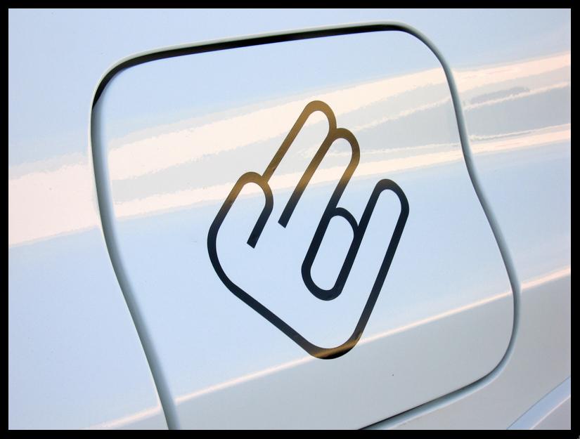 close-up of a white gas cap with a black decal of a hand making the rock-on gesture