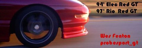1994 Ford Probe - The front corner of a red 1994 Ford Probe is visible, with text indicating '94' Elec Red GT'.