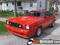 1978 Ford Mustang II - A bright red coupe, possibly a Mustang II, is parked on a residential street.