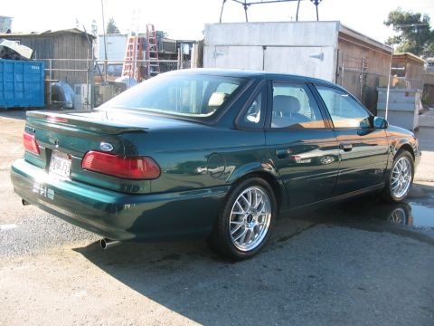 1995 Ford Taurus - This 1995 Ford Taurus is shown from the rear 3/4 angle, aftermarket wheels and a spoiler.
