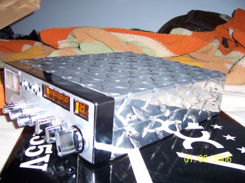 1985 Ford Bronco - A CB radio with a diamond plate finish is shown, resting on a black surface with white lettering.