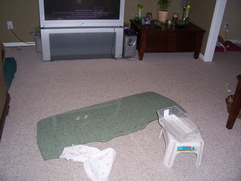 1978 Ford Bronco - A car window is shown on the floor, with a plastic bin and paper towels nearby.