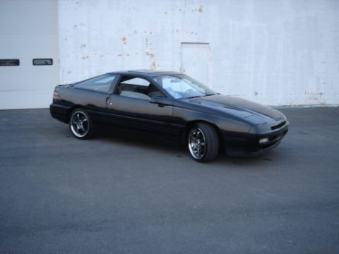 1990 Ford Probe - 3-Qtr view of 89 GT. GT features larger front opening in mid front fascia. Rear tail lights feature smoked lenses. Intergrated GT text plac…