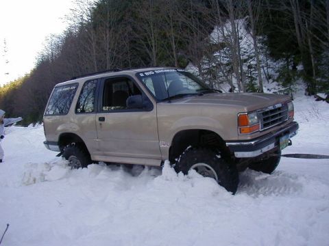 1994 Ford Explorer - A tan 1994 Ford Explorer is stuck in deep snow during a winter event.