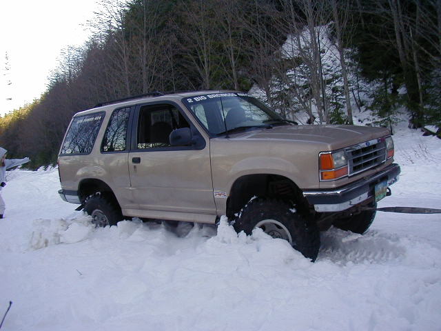 Tan 1994 Ford Explorer stuck in deep snow, front 3/4 view