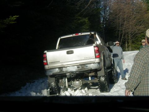 1994 Ford Explorer - Pickup truck with lifted suspension and large tires stuck in snow.