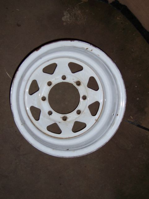 1983 Ford Bronco - A single white steel wheel with a common six-lug bolt pattern is shown against a dark background.