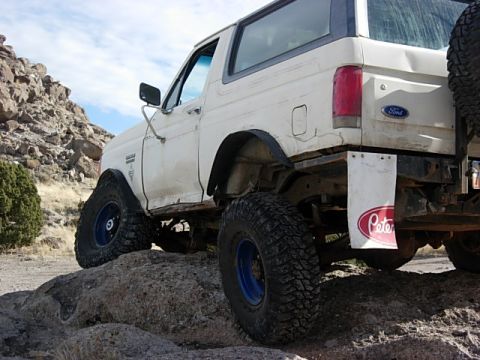 1987 Ford Bronco - White 1987 Ford Bronco navigating rocky terrain.
