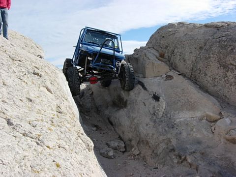 1987 Ford Bronco - This custom buggy is navigating a challenging rocky trail with steep inclines and tight spaces.