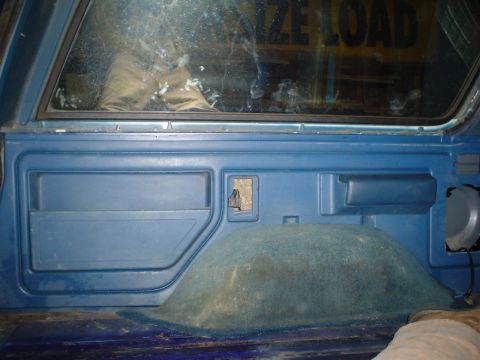 1984 Ford Bronco - Interior panel detail with a visible speaker and storage compartment. Text 'SIZE LOAD' is visible through the rear window.