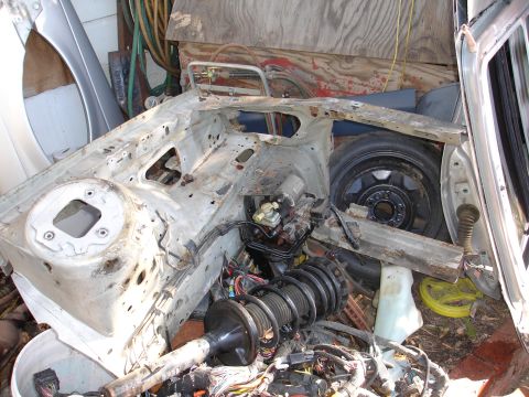 1992 Ford Taurus - Car chassis and components are piled up, suggesting a deconstruction or parts salvage operation.