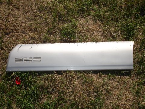 1992 Ford Taurus - A silver car door trim piece with embossed text is shown on a grassy surface.