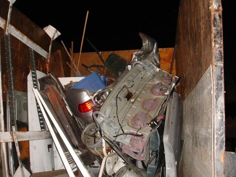 1992 Ford Taurus - Jumbled pile of damaged car parts, likely from a single vehicle, in a scrap bin.