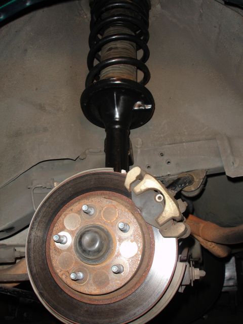 1995 Ford Taurus - This image shows a close-up view of a vehicle's rear brake rotor, caliper, and shock absorber assembly.