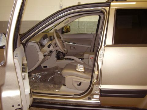 1997 Ford Taurus - The interior of a gold SUV is visible with the driver's side door open, showing the dashboard and seats.