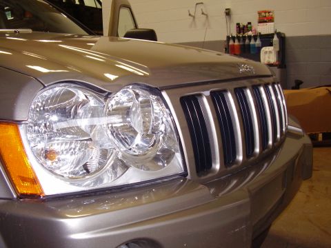 1997 Ford Taurus - Close-up of a Jeep Grand Cherokee's distinctive grille and headlights.
