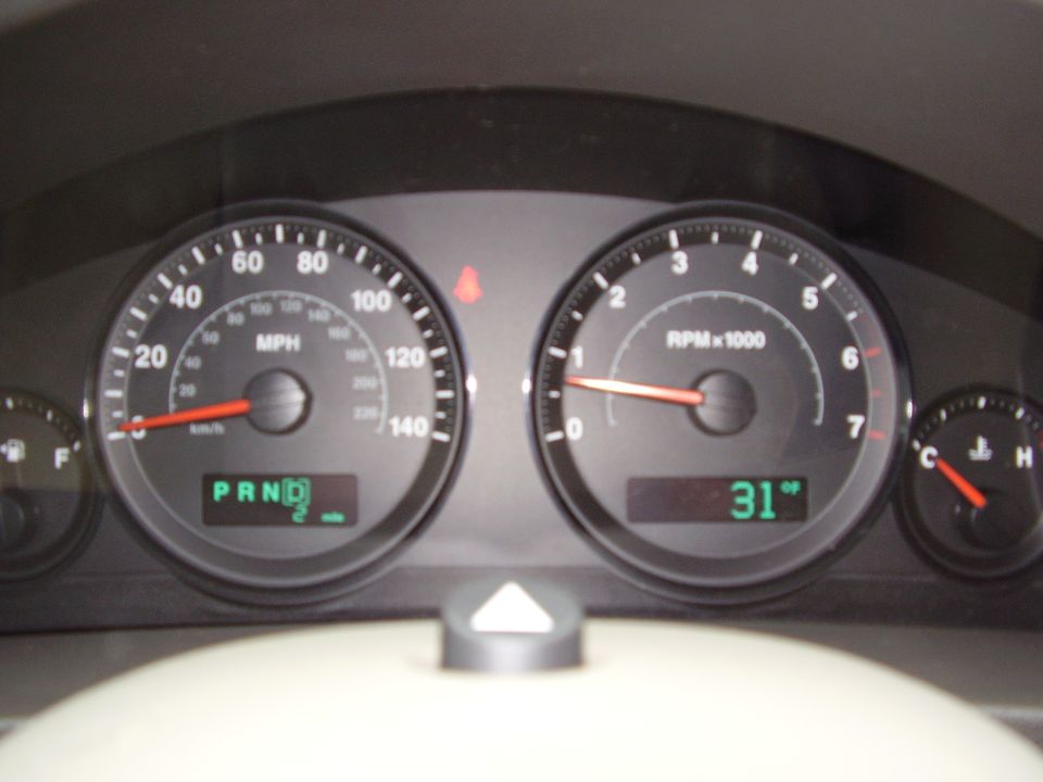 Dashboard gauges with speedometer, tachometer, and temperature gauge. Digital display shows 'PRND 2'