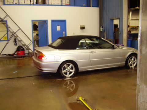 1997 Ford Taurus - Silver convertible parked inside a garage with water on the floor.