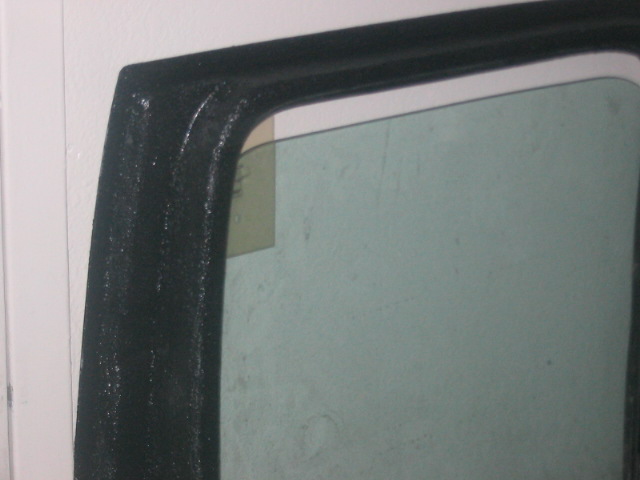 Black textured door frame and tinted window with a yellow sticker