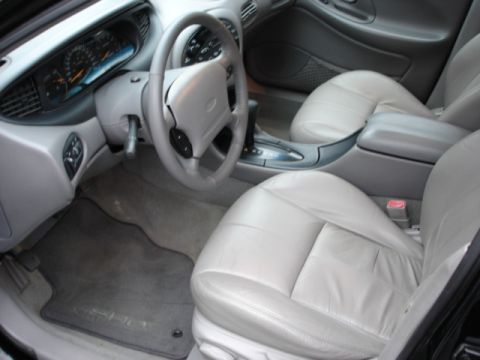 1998 Ford Taurus - The interior of a 1998 Ford Taurus, light-colored leather seats and a clear view of the dashboard and steering wheel.