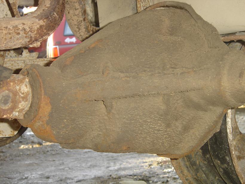 Close-up of a rusty rear differential housing with some exhaust pipe visible