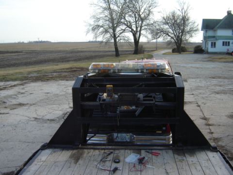 1992 Ford Bronco - Wiring and tools are laid out on a tow truck bed, ready for installation or repair, with emergency lights visible above.