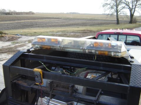 1992 Ford Bronco - Tow truck light bar and wiring detail, with a red pickup truck in the background.