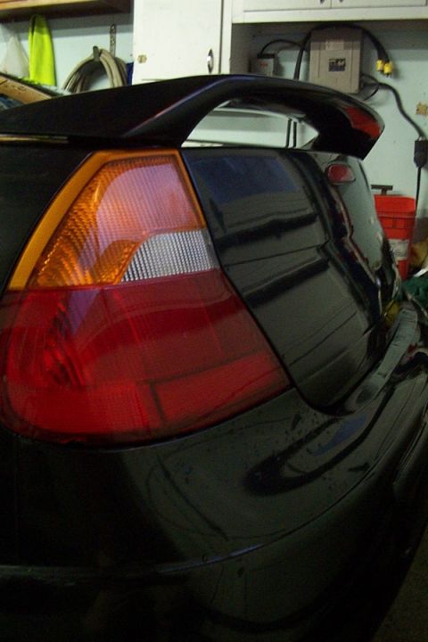 1999 Chrysler 300M - Close-up of a car's rear spoiler and red taillight with amber turn signal.