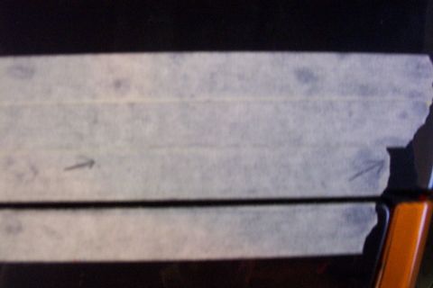 1999 Chrysler 300M - Masking tape is applied to a car part, obscuring some of its surface.
