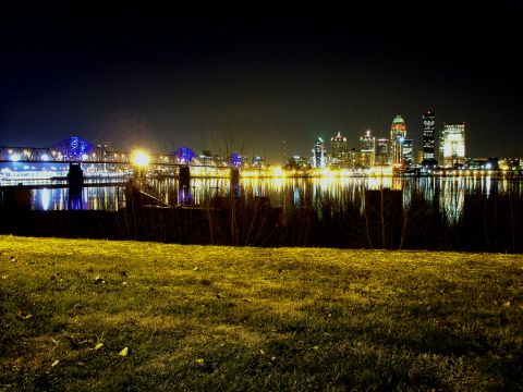 1994 Ford Probe - The lights of a city reflect on the water at night, with a bridge in the background.