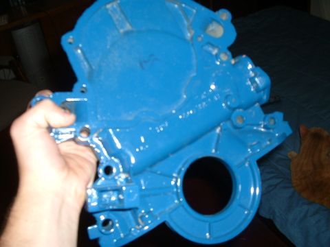 1985 Ford Bronco - A blue painted engine component is held up for inspection.