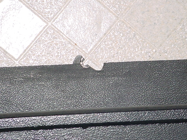 Close-up of black textured interior trim with a small metal clip