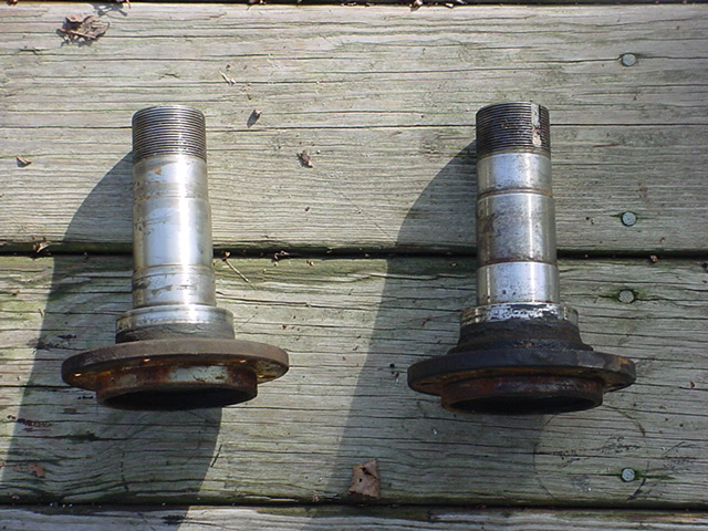 Two front wheel hubs sitting on a wooden surface