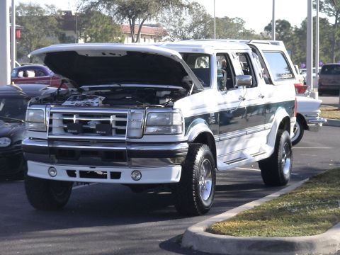 1993 Ford C-350 (Centurion Conversions) - A white Ford Bronco Centurion conversion with its hood up is parked outdoors.