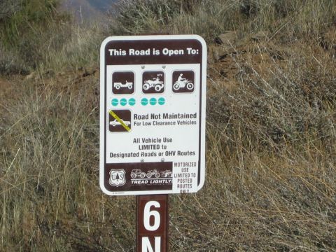 1990 Ford Bronco - close-up of a brown US Forest Service sign listing permitted off-road vehicles, mounted on a post beginning with the number 6N.