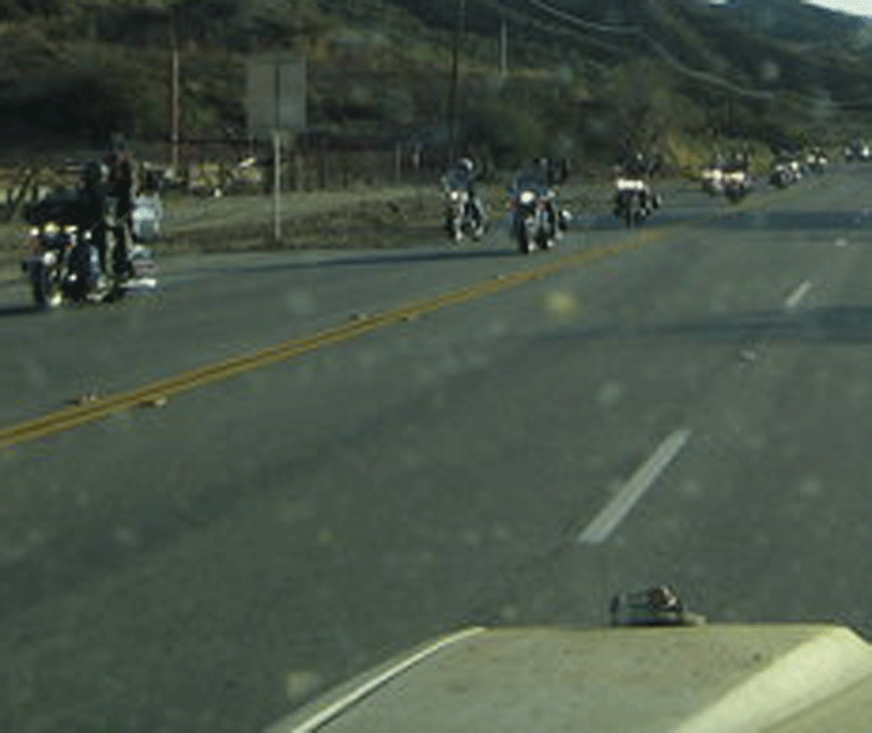 Group of motorcycles on a rural highway viewed through a spotted windshield
