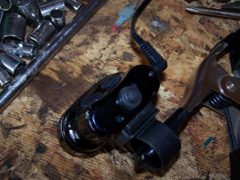 1986 Ford Bronco - An underhood light assembly is shown with various tools, including sockets and a clamp, on a wooden workbench.