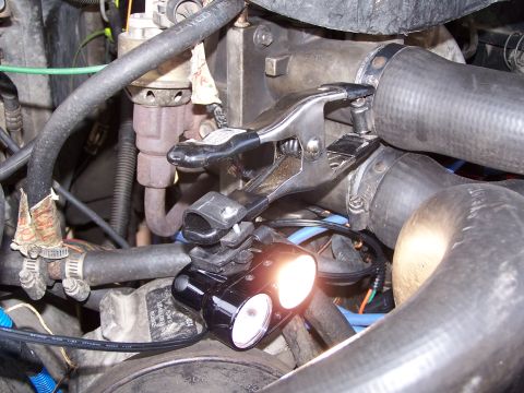 1986 Ford Bronco - A temporary underhood light is attached to engine components with a clamp.