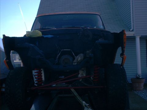 1978 Ford Bronco - Front view of a 1978 Ford Bronco with its hood off, revealing the engine bay and suspension system.