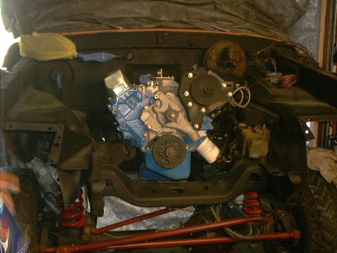 1978 Ford Bronco - The engine bay of a vehicle is shown with a blue engine installed, suggesting ongoing work or a rebuild.