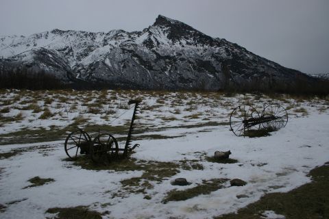 2003 Jeep TJ - Antique farm machinery rests in a winter landscape beneath a , snow-capped mountain.