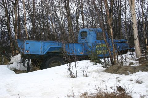 2003 Jeep TJ - An old blue truck sits abandoned in a snowy, wooded area.
