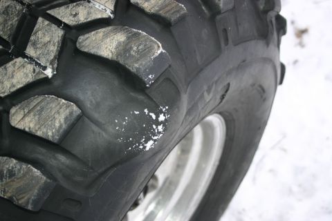 2003 Jeep TJ - A close-up view of an off-road tire shows its aggressive tread pattern and some white residue on the rubber.