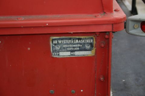 2003 Jeep TJ - A metal identification plate is attached to a red vehicle component, displaying manufacturer details and a serial number.