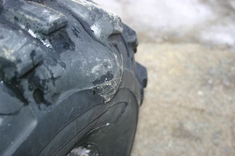 2003 Jeep TJ - A close-up view of a tire, likely from an off-road vehicle, shows its tread pattern and some accumulated dirt and moisture.