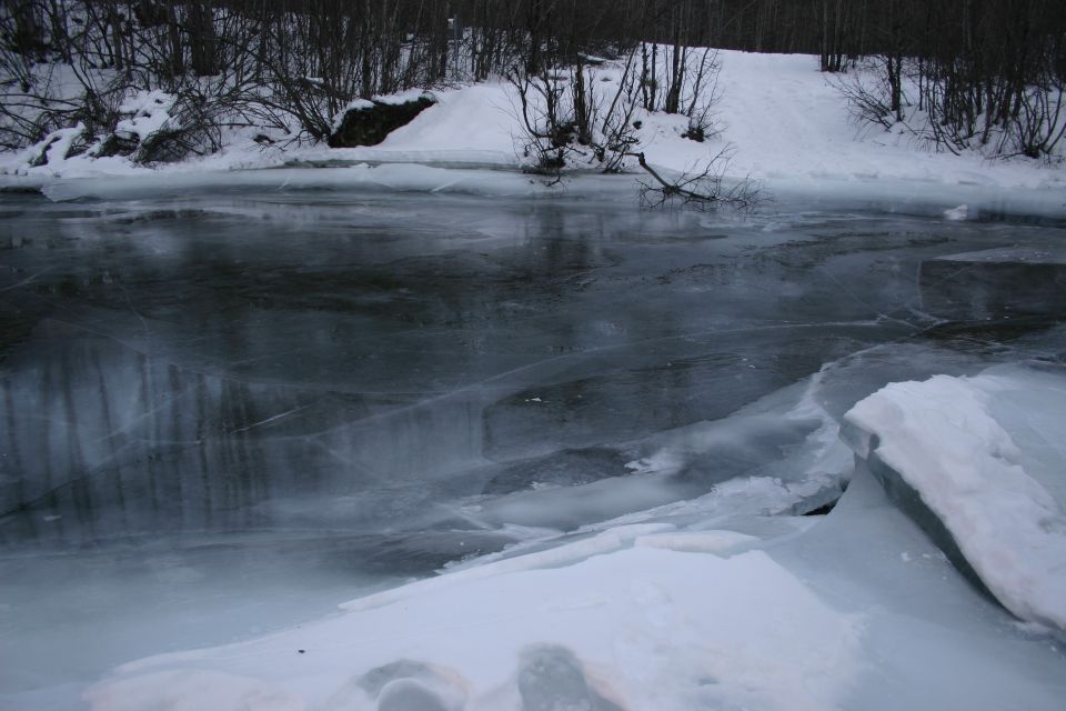 Frozen river with ice floes and snow-covered trees on the bank